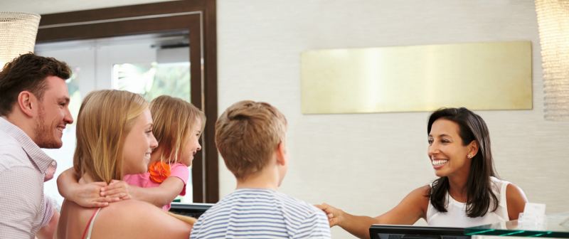 Une famille accueillie à la réception d'un hôtel du réseau
